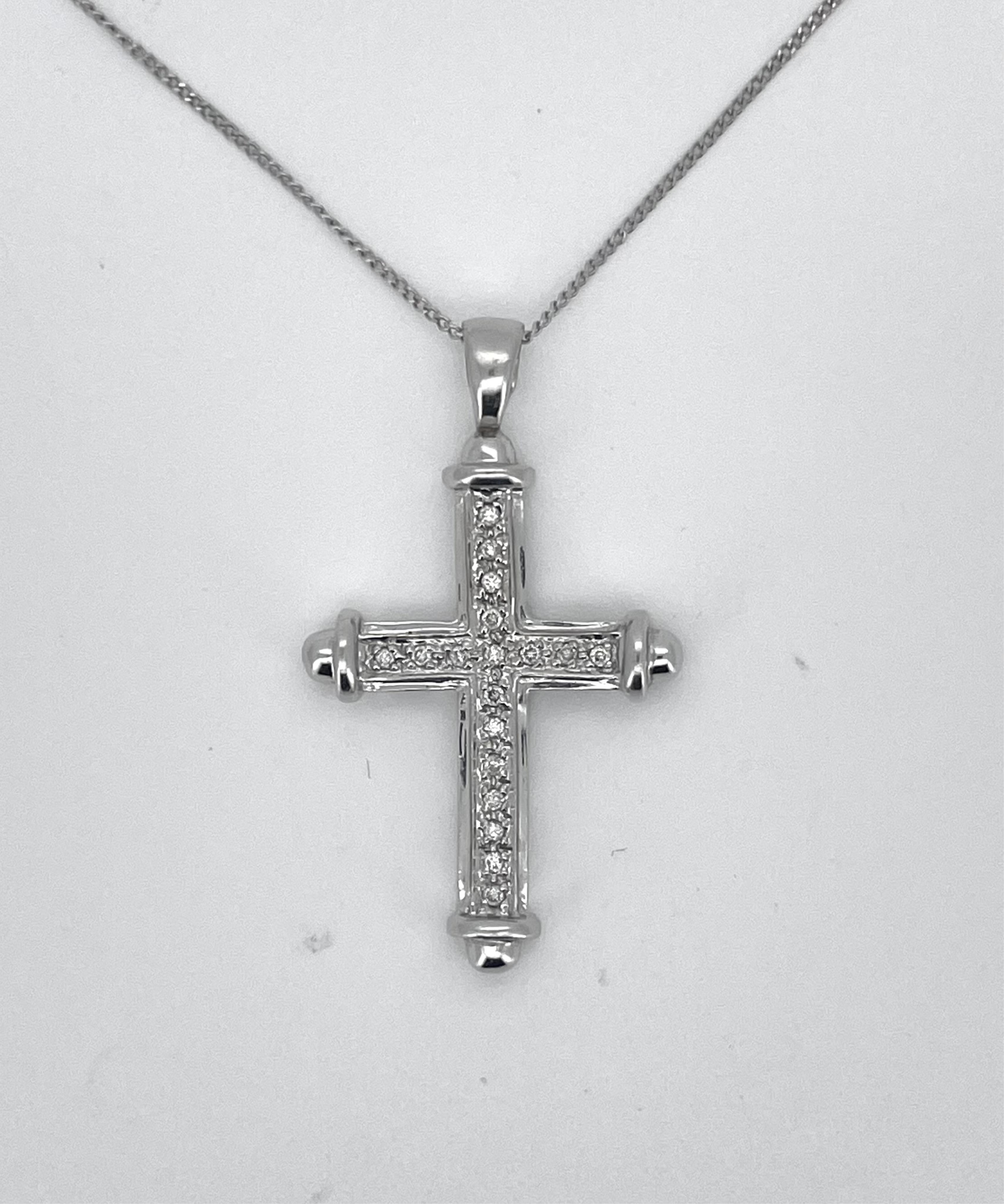 A modern 9ct white gold and diamond chip cluster set cross pendant, overall 36mm, on a white metal fine link chain stamped 375, 48cm.